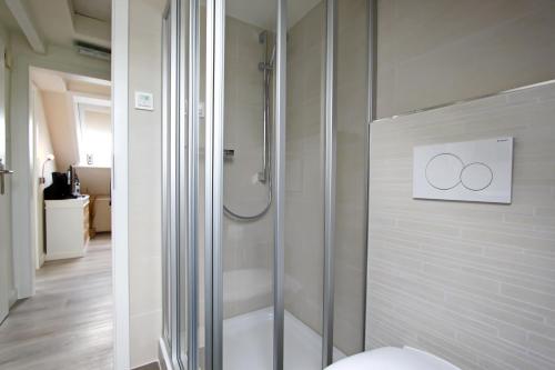 a bathroom with a shower with two rings on the wall at Syltrose in Hörnum