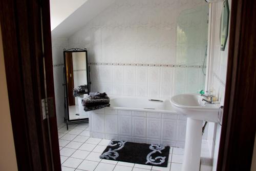 een badkamer met een wit bad en een wastafel bij Murray's Mountain View in Castlemaine