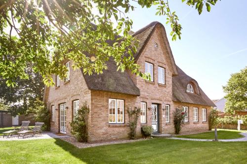 ein großes Backsteinhaus mit einem Gameradach in der Unterkunft Reethüs Maj - links in Utersum