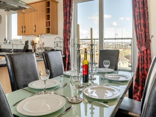 a dining room table with a bottle of wine on it at Beachview in Llanelli