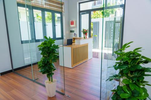 an office with two potted plants in the middle of a lobby at HomyPlus Apartment in Ho Chi Minh City