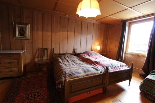 シャトー・デーにあるLes Bossonsの木製の壁のベッドルーム1室(ベッド1台付)