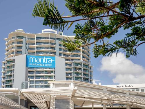 een groot wit gebouw met een bord erop bij Mantra Mooloolaba Beach in Mooloolaba
