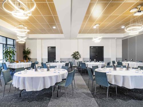 een conferentieruimte met witte tafels en stoelen bij Mantra Mooloolaba Beach in Mooloolaba