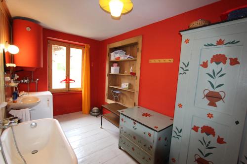 シャトー・デーにあるLes Bossonsの赤い壁のバスルーム(トイレ、洗面台付)