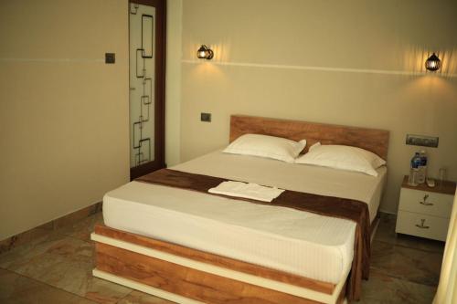 a bedroom with a large bed with a wooden headboard at Kghomestay in Pallipuram