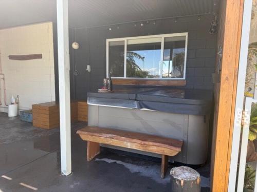 a building with a bench in a room with a tub at Frangipani Studio PET FRIENDLY!!! in Ulladulla