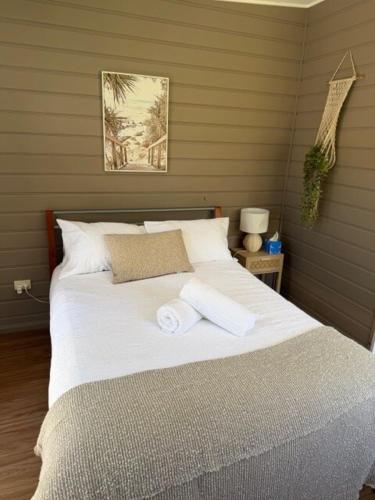 a bedroom with a bed with two towels on it at Frangipani Studio PET FRIENDLY!!! in Ulladulla