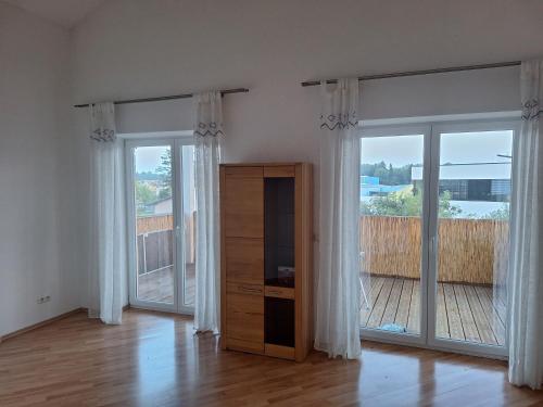 a living room with sliding glass doors and a dresser at Familienwohnung Emprechting in Emprechting