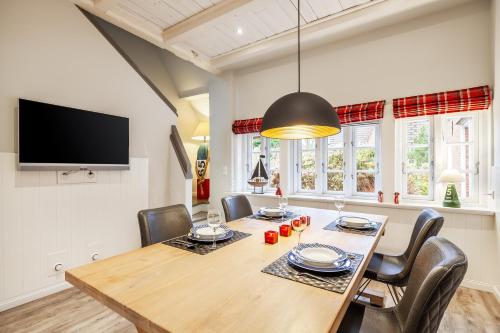 a dining room with a wooden table and chairs at FöhrEuch 2 in Borgsum