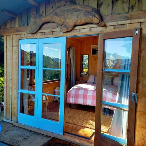 a room with a bed and a glass door at Delightful Dolphin 'Lodge' in Akaroa