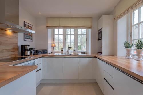 a kitchen with white cabinets and a sink at Landhaus Meta in Wrixum