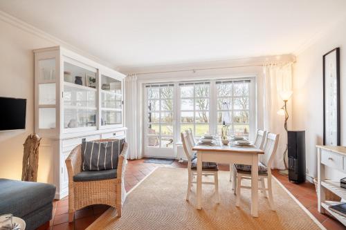 una sala da pranzo con un tavolo e sedie in una stanza di Hausteil Tornerose a Witsum