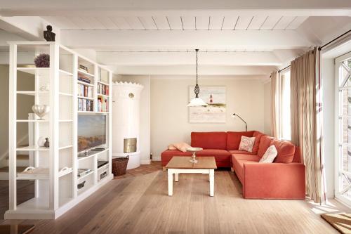 een woonkamer met een rode bank en een tafel bij Reethüs Marta - rechts in Utersum