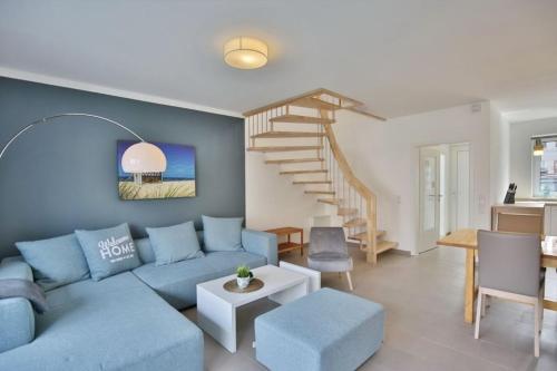 a living room with a blue couch and stairs at City Marina, CM20a in Cuxhaven
