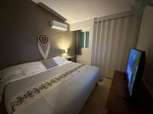 a hotel room with a bed and a television at Casa Linda in Campeche