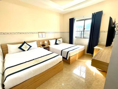 a hotel room with two beds and a window at Khách Sạn Ba Đoàn 1 in Con Dao