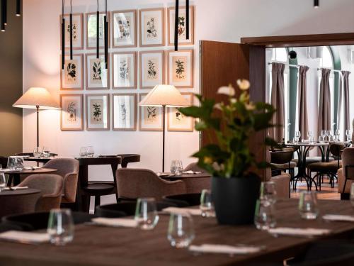 una sala da pranzo con tavoli e sedie con fiori sopra di Mercure Maintenon a Maintenon