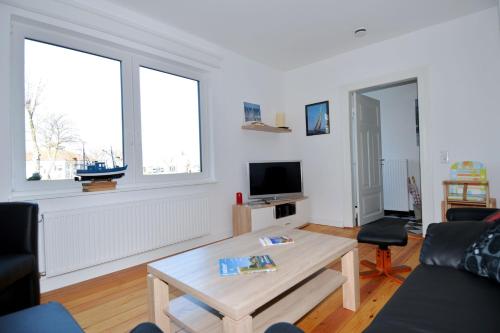 a living room with a coffee table and two windows at Fischers Fritz - Brückstr 32 in Heiligenhafen