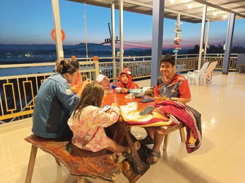 een groep mensen aan een tafel op een cruiseschip bij ชมวิว บึงโขหลง in Ban Don Klang