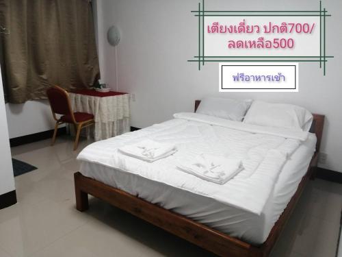 ein Bett in einem Schlafzimmer mit einem Tisch und einem Stuhl in der Unterkunft ชมวิว บึงโขงหลง in Bung Khong Long