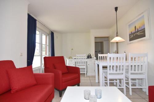 a living room with red chairs and a table at Luv & Lee, Whg 3 in Westerland