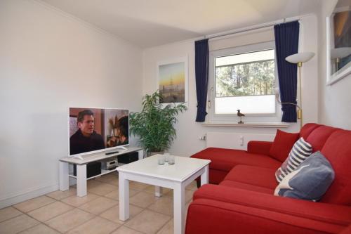 a living room with a red couch and a tv at Luv & Lee, Whg 3 in Westerland