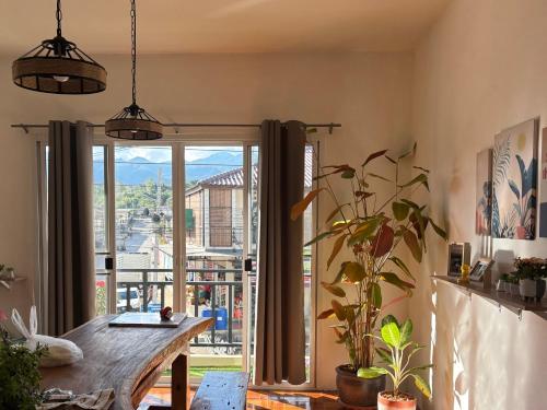 una sala da pranzo con un tavolo e una grande finestra di Pai Local Apartment a Pai