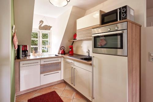 a kitchen with a refrigerator and a microwave at Entennest im Witthüs in Nieblum