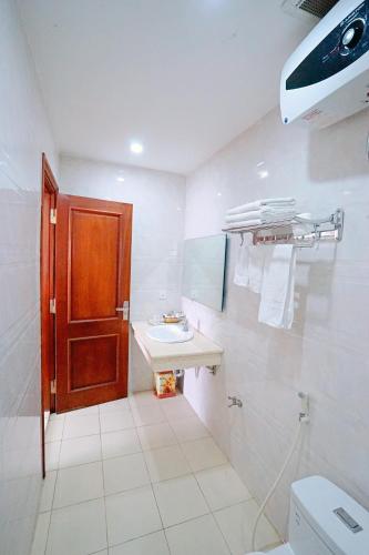 a bathroom with a toilet and a sink and a door at Thuan Thanh Hotel in Ninh Binh