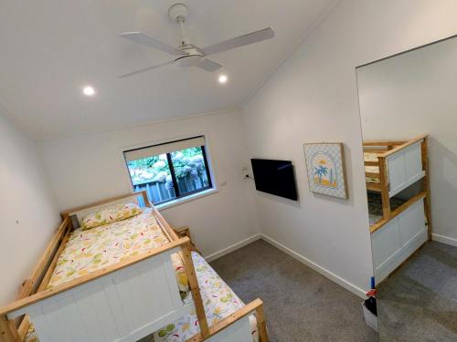 a bedroom with two bunk beds and a window at Mollymook Den Coastal Retreat - Walk to Beach & Town in Mollymook