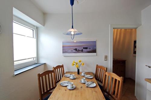 een eetkamer met een houten tafel en stoelen bij Strandmuschel in Hörnum