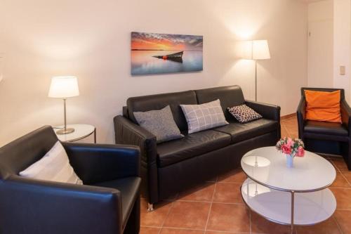 a living room with two couches and a table at Stranddüne, D13 in Duhnen