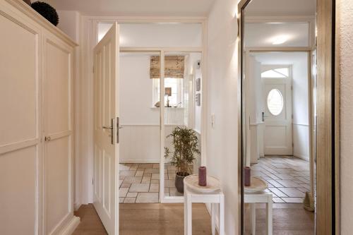 a hallway with two white stools and a plant at Deichgraf in Dunsum