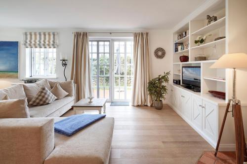 a living room with a couch and a tv at Deichgraf in Dunsum