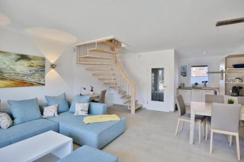 a living room with a blue couch and a staircase at City Marina, CM24d in Cuxhaven