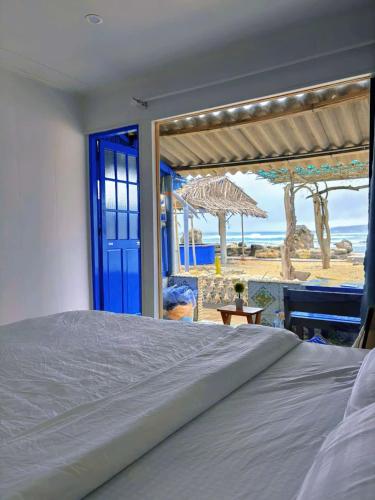 a bedroom with a bed and a view of the beach at Long Vĩ hotel - đảo Phú Quý in Cu Lao Thu
