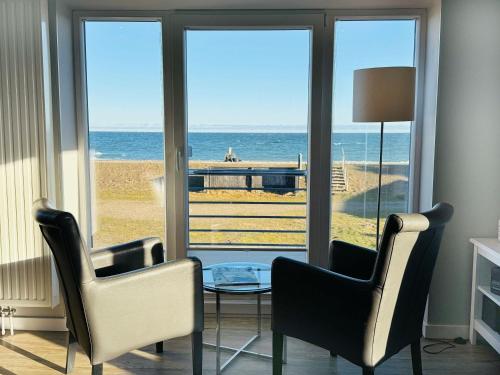 a living room with two chairs and a view of the beach at Apartment Priwall Teichhof Fehmarn in Wenkendorf