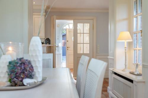 a dining room with a table and white chairs at Ferienhaus Hideaway in Kampen