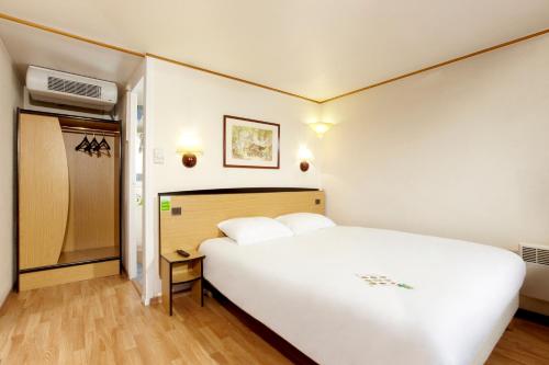 a bedroom with a large white bed in a room at Campanile Rouen Nord - Barentin in Barentin