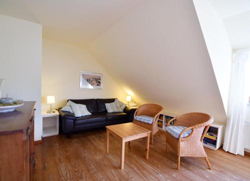 a living room with a couch and chairs and a table at Im Apfelgarten in Oldsum