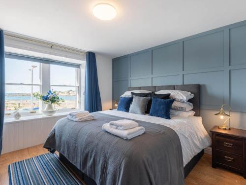 een slaapkamer met een groot bed met handdoeken erop bij Shorefront Apartment in Anstruther