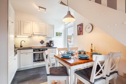 a kitchen with a wooden table and chairs in a kitchen at Südstranddomizil 56 in Wyk auf Föhr
