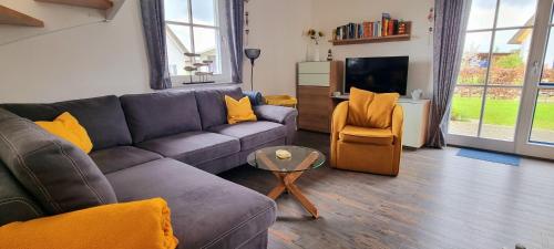 a living room with a couch and a chair at Reethaus "Melsa" in Zierow