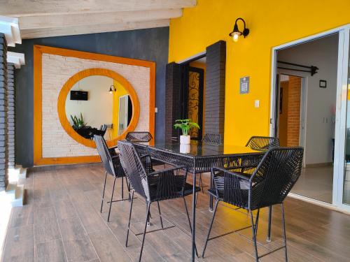 una sala da pranzo con tavolo e sedie neri di Casa Rinconcito Del Sol Alberca Climatizada a Tonatico