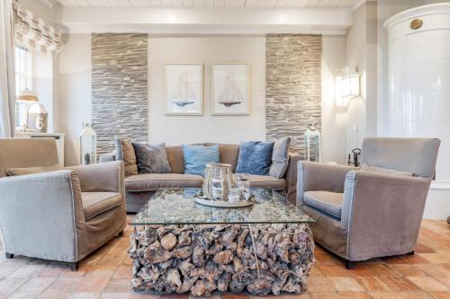 a living room with a couch and a table and chairs at Hüs Lillebo in Hedehusum