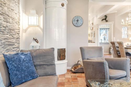 a living room with two chairs and a clock on the wall at Hüs Lillebo in Hedehusum