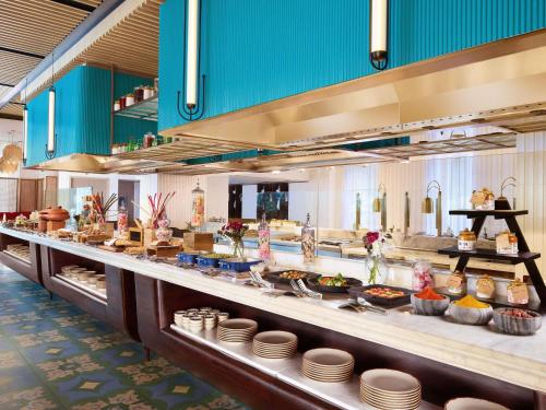 a buffet line with plates and other food at Novotel Goa Panjim in Panaji