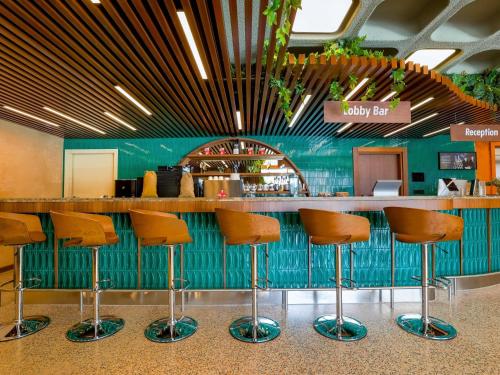 a bar in a restaurant with brown stools at ibis Styles Istanbul Kurtkoy in Istanbul