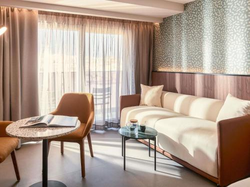 een woonkamer met een bank en een tafel bij Novotel Malta Sliema in Il-Gżira